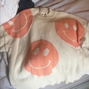 Smiley Face Cream and Orange Sweater